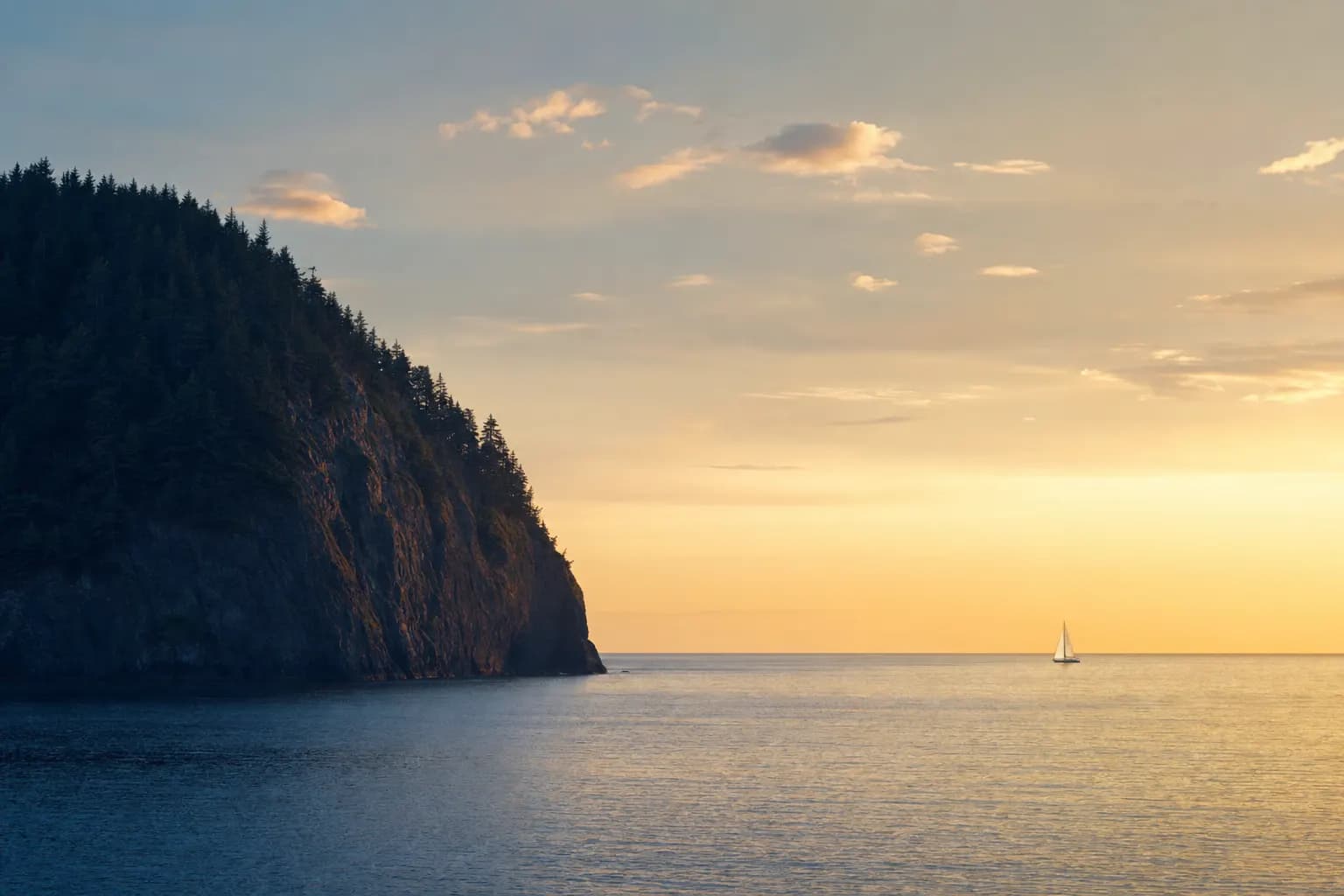 AI-generated image of a sunset seascape: a massive dark forested headland fills the left of the frame while a single tiny white sailboat sits far out on the golden water to the right, the two holding the frame level.
